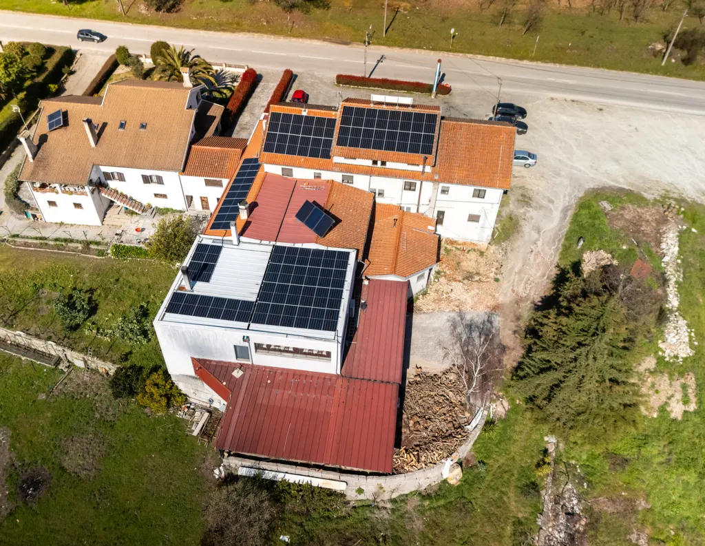 Vista aérea de edifícios com coberturas de telha, chapa metálica e terraço, vários com módulos fotovoltaicos — obra JP Solar Solutions